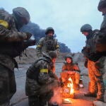 Soldados ucranianos se calientan en una hoguera en las inmediaciones de Kiev