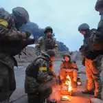 Soldados ucranianos se calientan en una hoguera en las inmediaciones de Kiev
