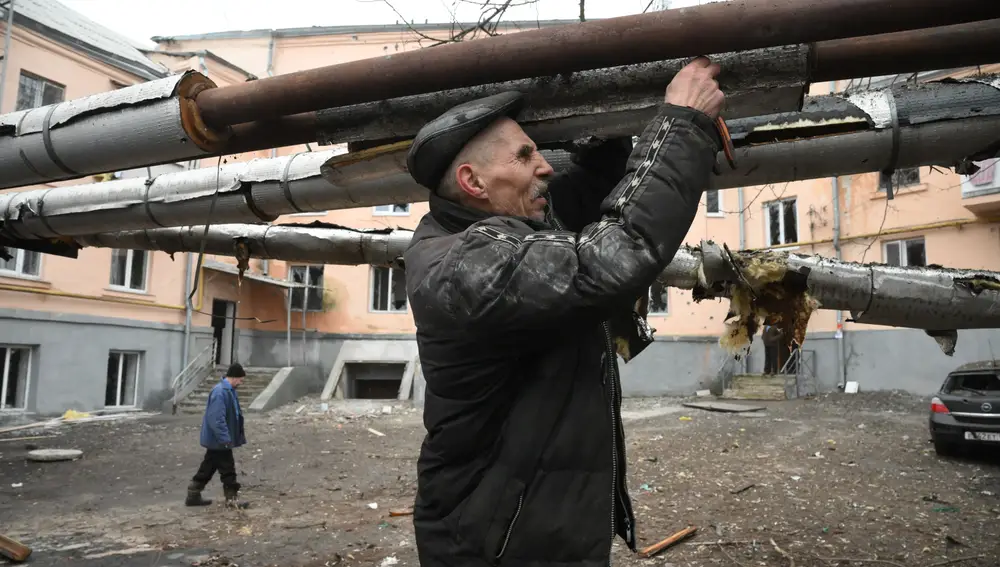 Un hombre repara las tuberías dañadas durante el reciente bombardeo, en Donetsk,