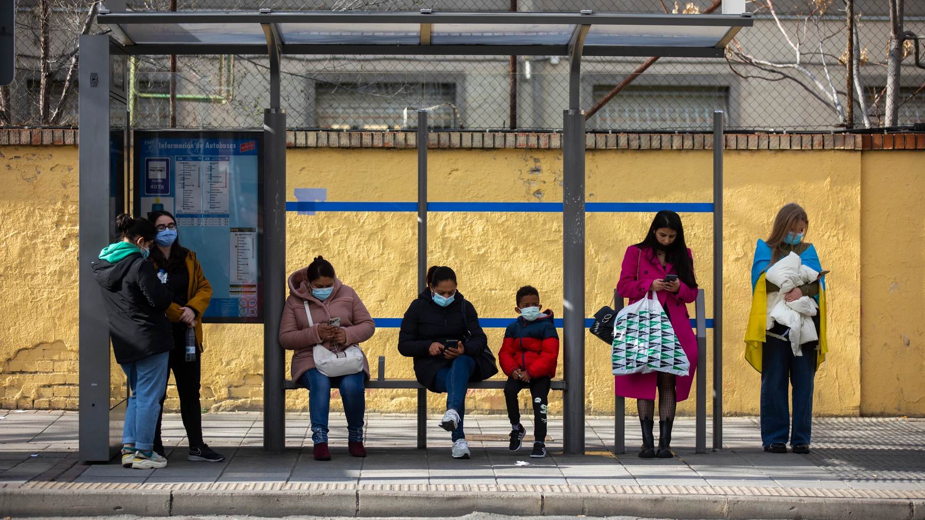 Gente usando su teléfono móvil en barrios de Madrid.