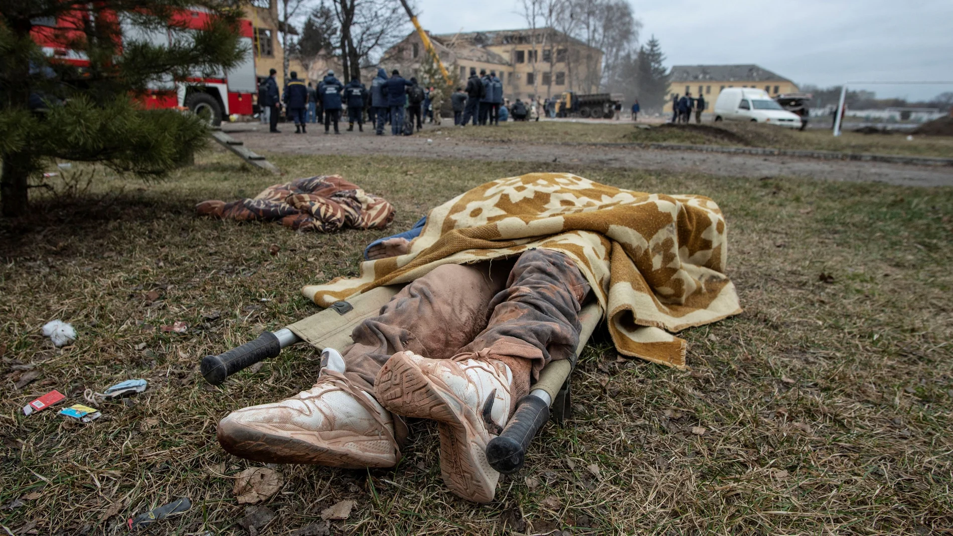 El cuerpo de una persona yace en el suelo junto a un edificio militar que, según las fuerzas terrestres ucranianas, fue destruido por un ataque aéreo, en la región de Sumy