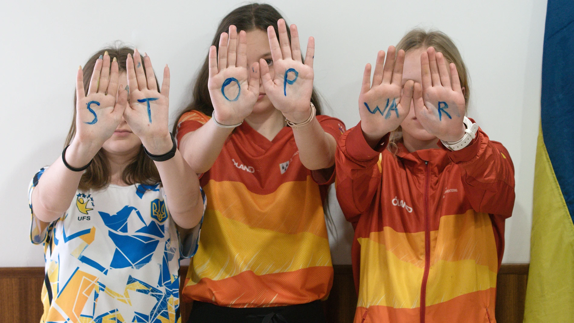Tres niñas ucranianas muestran sus manos con el mensaje 'Stop War' en El Tiemblo (Ávila), donde se encuentran acogidas