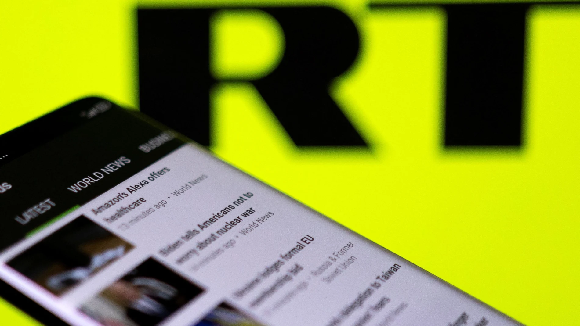 RT app is seen on a smartphone in front of their logo in this illustration taken February 28, 2022. REUTERS/Dado Ruvic/Illustration