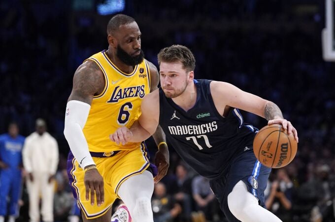 Luka Doncic intenta eludir la defensa de LeBron James