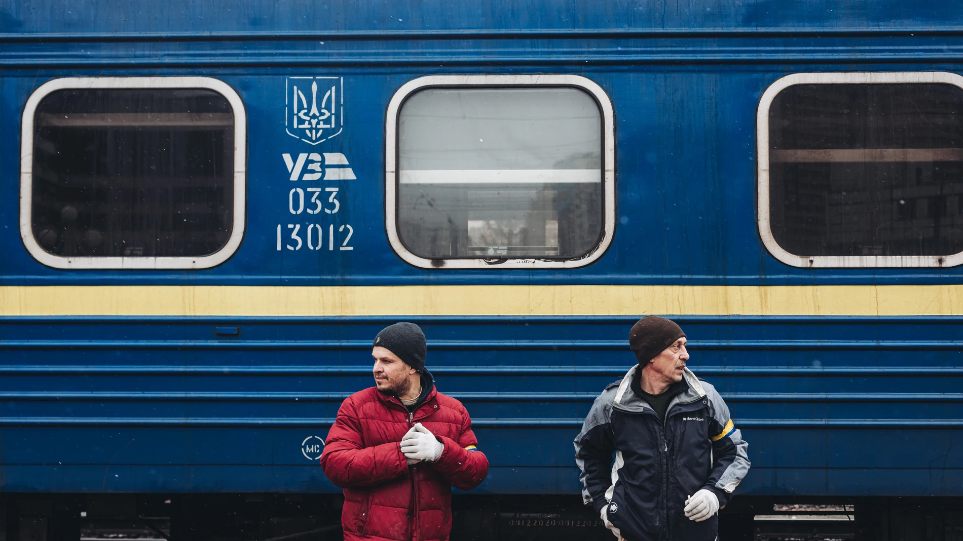 Dos hombres frente a un tren en la estación de tren de Kiev este jueves