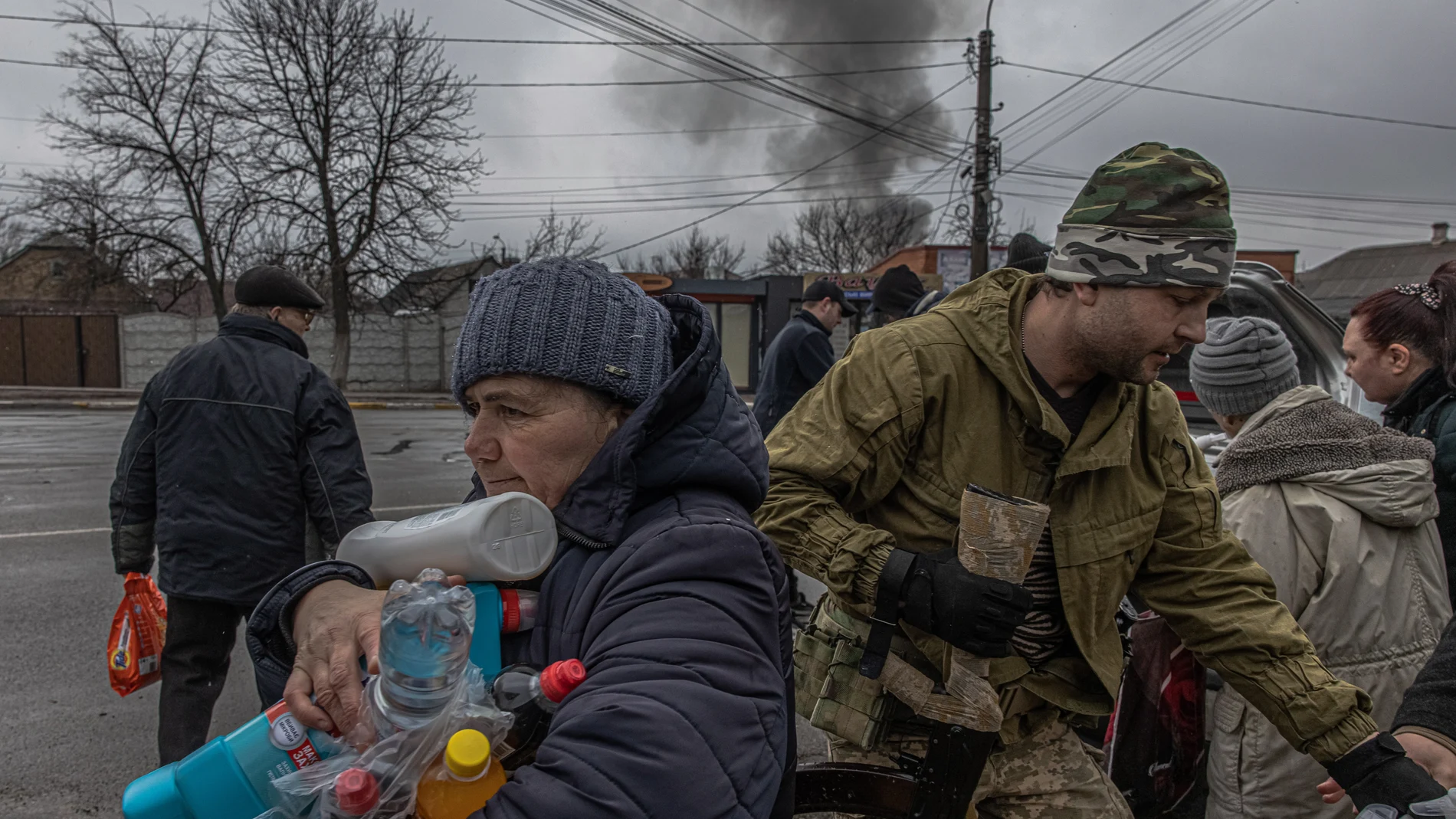 Una mujer recibe agua y productos de higiene distribuidos por el ejército ucraniano a residentes locales en la ciudad de Irpin