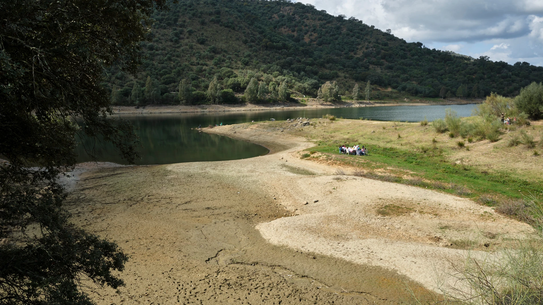 Un grupo de personas almuerzan a orillas del embalse de La Minilla en la localidad sevillana de El Ronquillo. EFE/Julio Muñoz