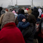 Varias personas y niños esperaban para cruzar a Rumanía, en el paso fronterizo de Porubne, en el oeste de Ucrania, el pasado mes de marzo