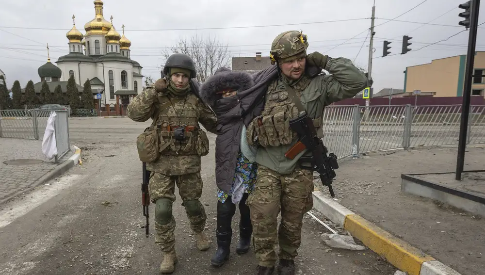Militares ucranianos ayudan a una anciana en la ciudad de Irpin, cerca de Kiev