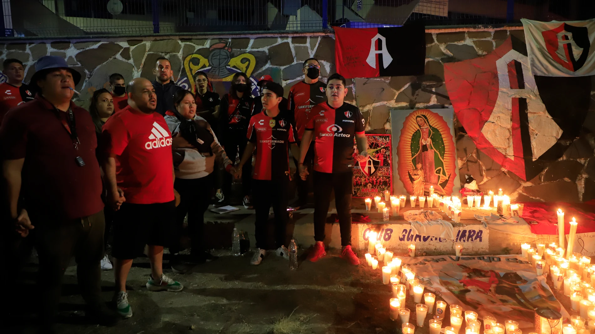 Aficionados del Club Atlas, encienden velas en la madrugada de este domingo, en las inmediaciones del estadio Jalisco, en la ciudad de Guadalajara en Jalisco (México), debido a los actos de violencia ocurridos en el partido ante Querétar