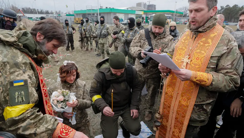 Kyiv (Ukraine), 06/03/2022.- Ukrainian territorial defense fighters Valeriy (C-R) and Lesya (C-L) during their wedding ceremony at a blockpost near Kyiv (Kiev), Ukraine, 06 March 2022. Russian troops entered Ukraine on 24 February leading to a massive exodus of Ukrainians to neighboring countries as well as internal displacements. (Rusia, Ucrania) EFE/EPA/SERGEY DOLZHENKO