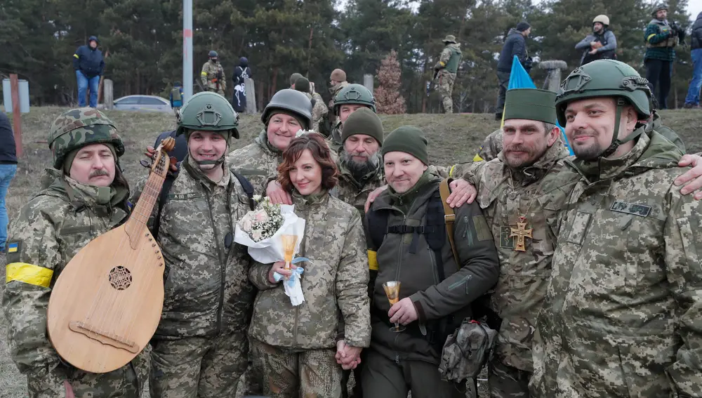 Kyiv (Ukraine), 06/03/2022.- Ukrainian territorial defense fighters Valeriy (C-R) and Lesya (C-L) pose for a group photo following their wedding ceremony at a blockpost near Kyiv (Kiev), Ukraine, 06 March 2022. Russian troops entered Ukraine on 24 February leading to a massive exodus of Ukrainians to neighboring countries as well as internal displacements. (Rusia, Ucrania) EFE/EPA/SERGEY DOLZHENKO
