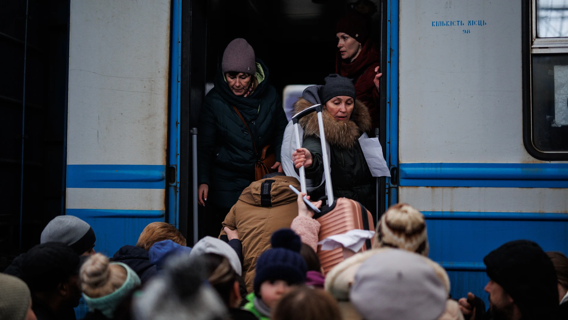 Varias personas suben a un tren en la estación de tren de Lviv (Ucrania) para huir del conflicto bélico
