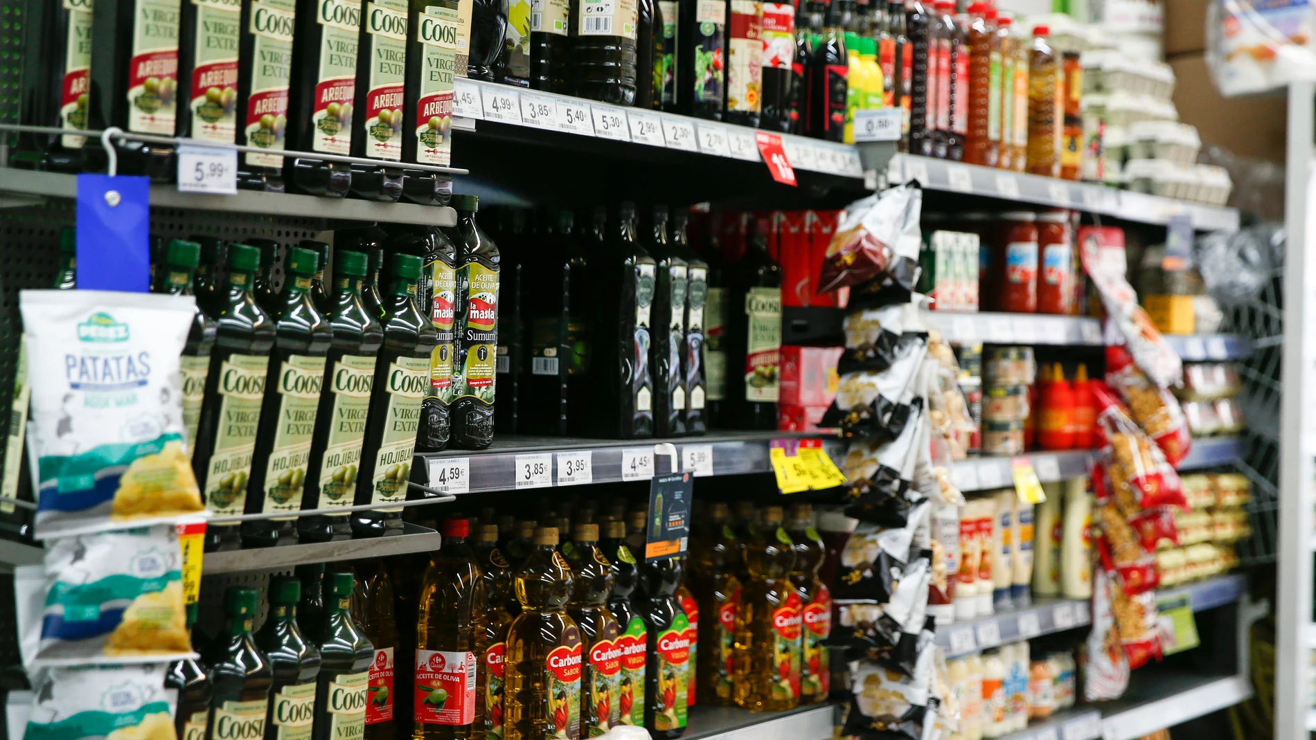 Estanterías con botellas de aceite en un supermercado.