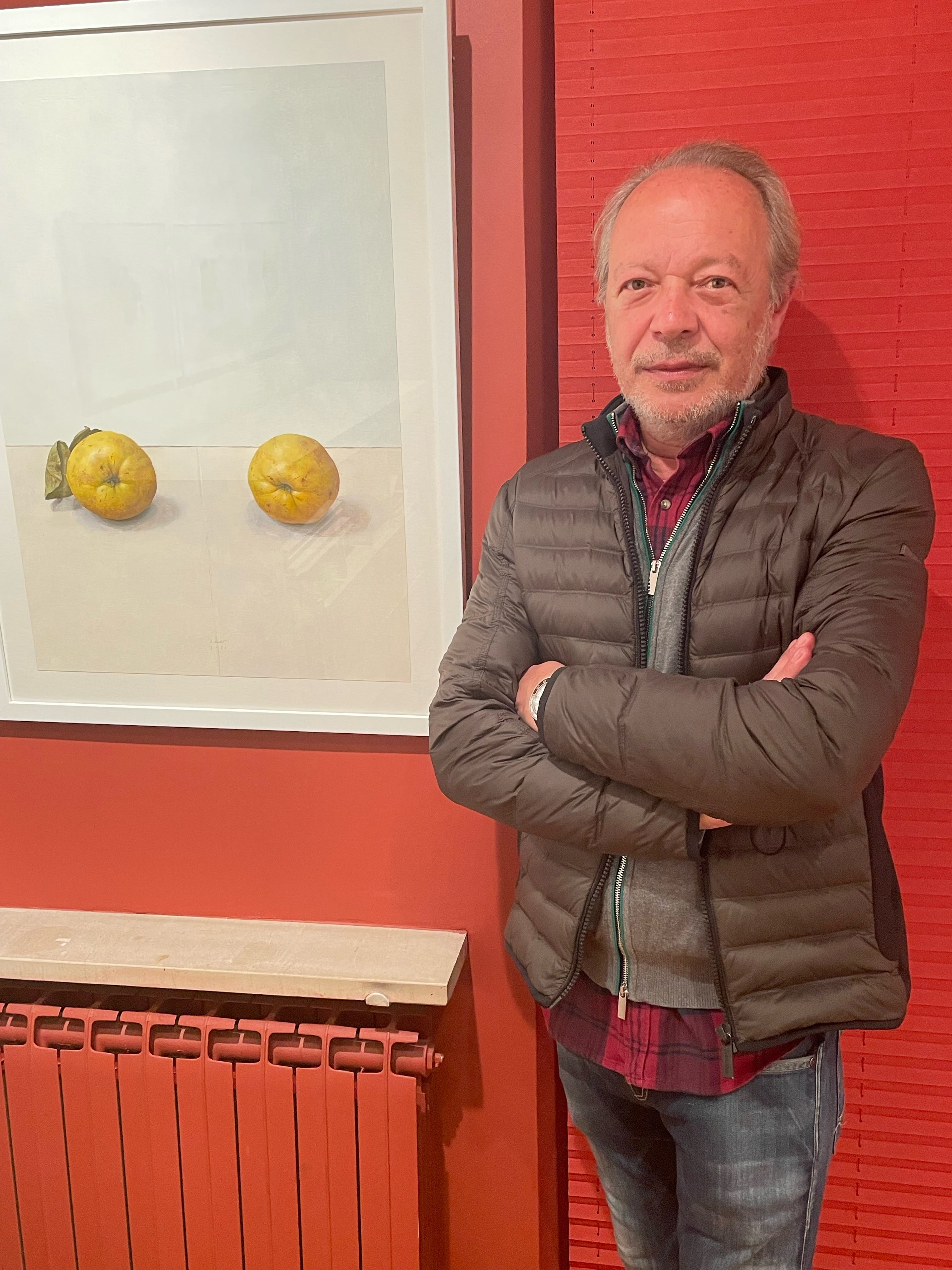 Ernrique Reche junto a uno de sus cuadros de la serie de membrillos
