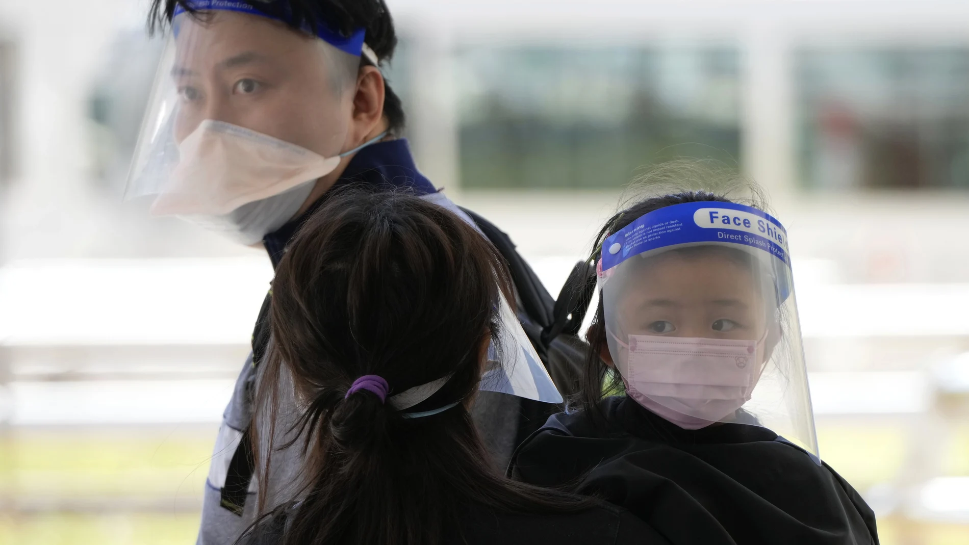Una familia espera un taxi después de salir del Hospital Queen Elizabeth en Hong Kong