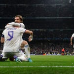 El delantero francés del Real Madrid Karim Benzema (de espaldas) celebra con Luka Modric el pase del equipo blanco a los cuartos de final de la Champions tras derrotar al PSG
