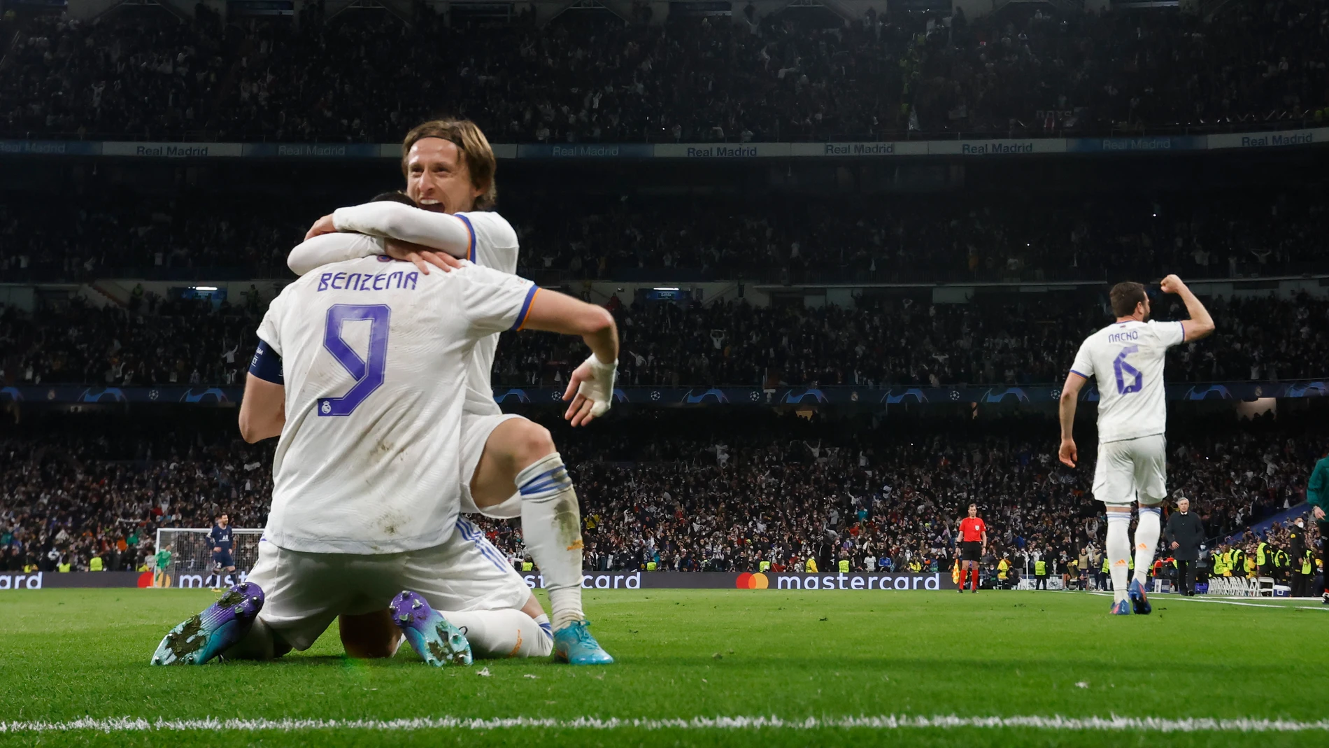 El delantero francés del Real Madrid Karim Benzema (de espaldas) celebra con Luka Modric el pase del equipo blanco a los cuartos de final de la Champions tras derrotar al PSG