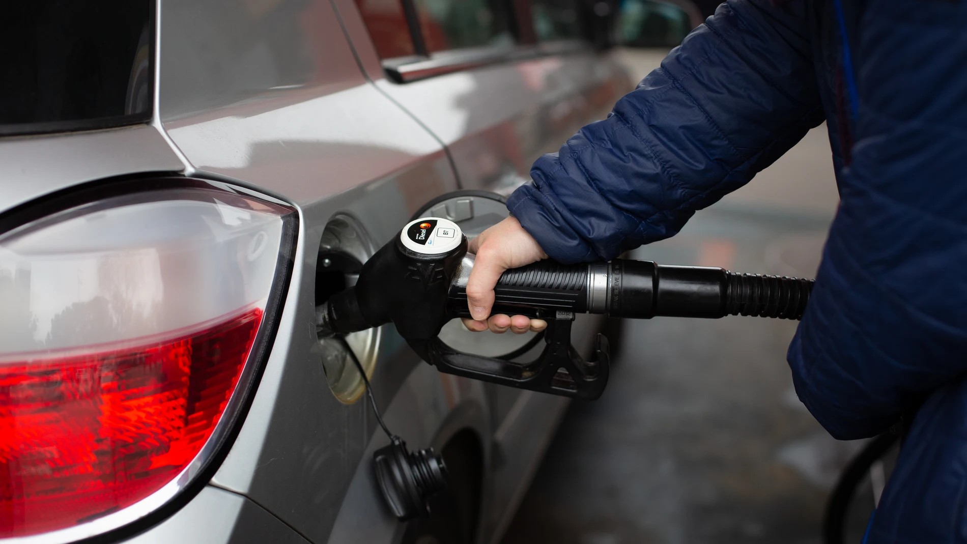 Un hombre reposta en una gasolinera