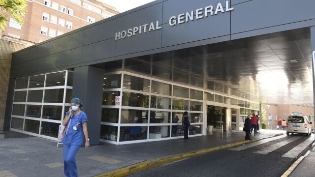 Una sanitaria protegida con mascarilla sale del hospital Virgen del Rocío de Sevilla