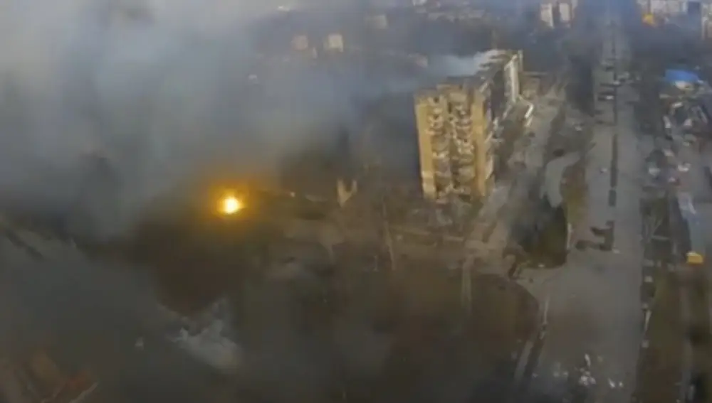 Esta imagen tomada de un video proporcionado por el Batallón Azov muestra una vista aérea del humo que se eleva desde varios edificios y un destello de luz de una aparente explosión en Mariupol