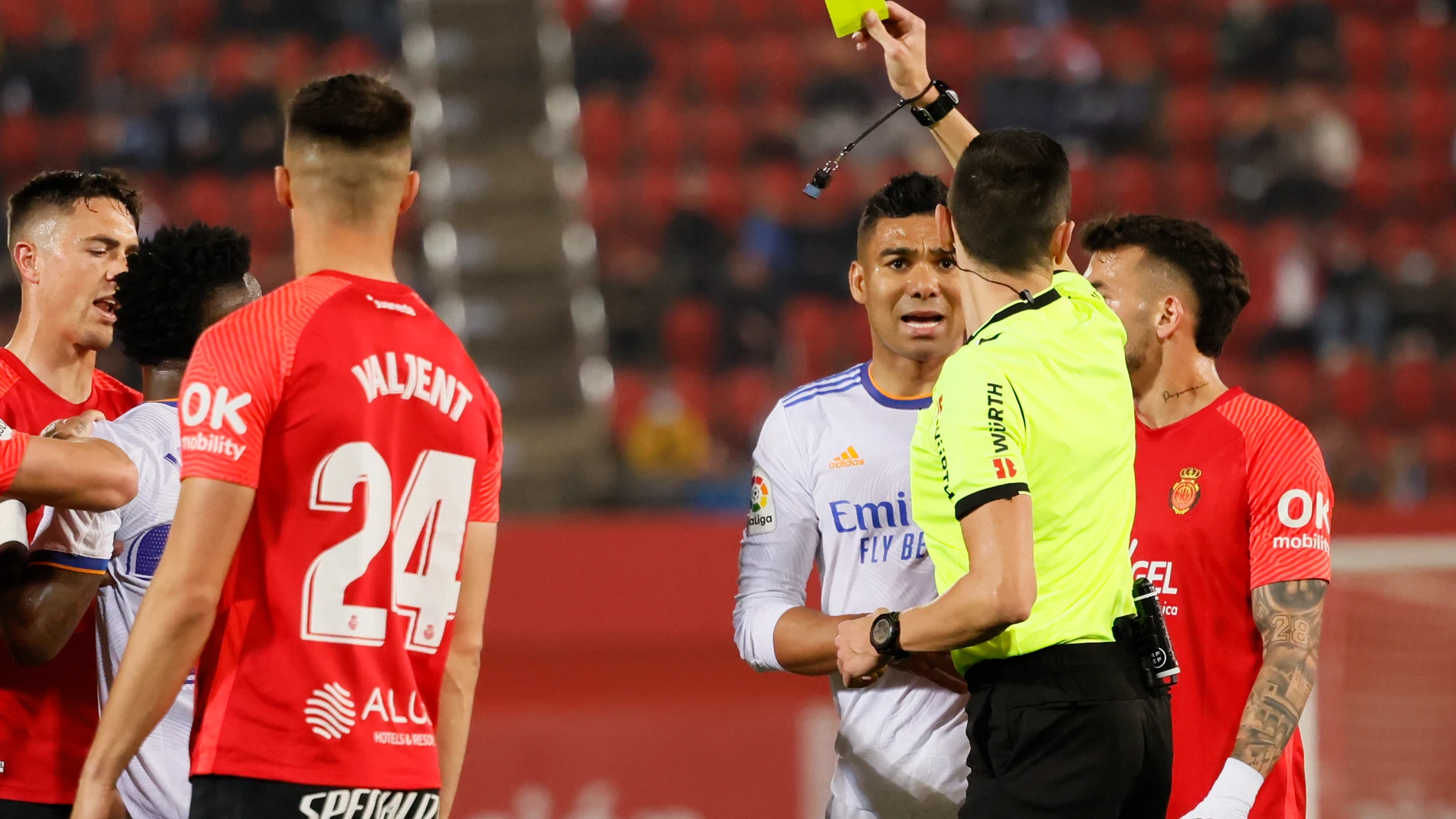 El delantero brasileño del Real Madrid Vinícius Jr (2i) y el delantero del RCD Mallorca Ángel (no aparece) ven una tarjeta amarilla durante el partido de LaLiga Santander
