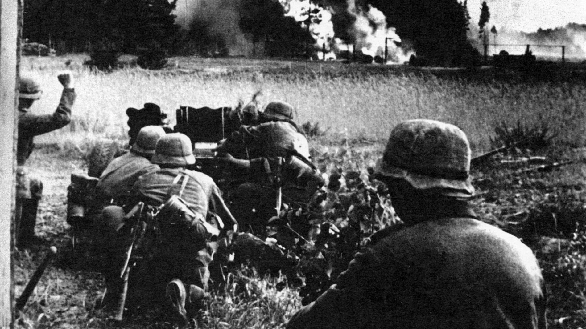 Una pieza contracarro alemana dispara contra una columna soviética, al fondo se puede adivinar la silueta de un vehículo en llamas