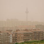 Una mujer observa la calima y la lluvia desde el mirador del Cerro del Tío Pío, Madrid