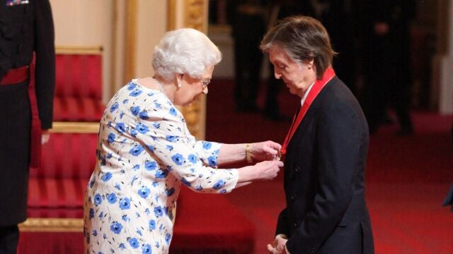 Isabel II condecorando a Paul McCartney, en 1997
