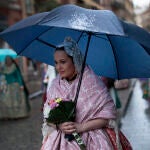 Una fallera se protege de la lluvia con un paraguas a falta de dos días y medio para que acaben las Fallas de 2022