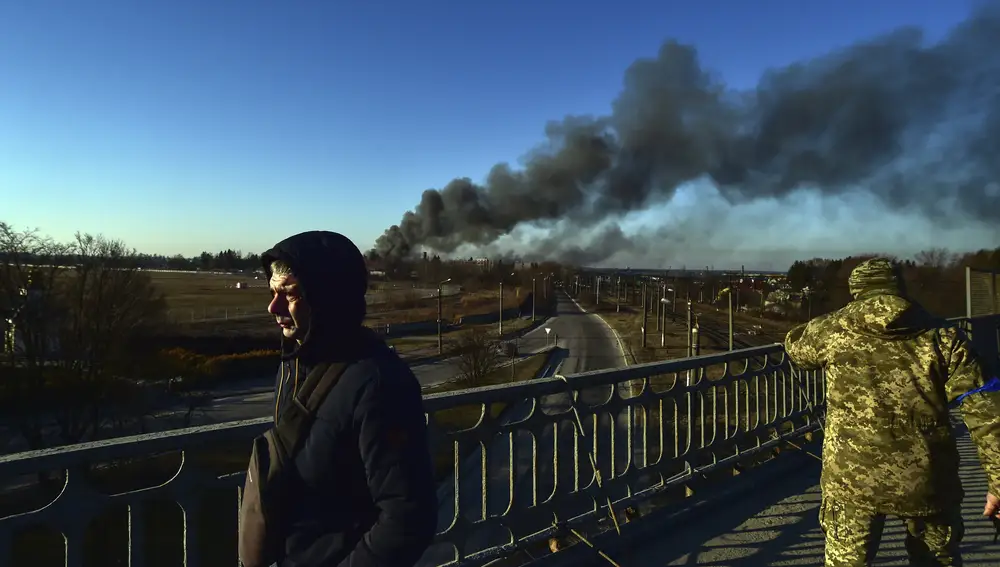 Un soldado ucraniano observa una columna de humo tras una explosión en el aeropuerto de Leópolis
