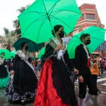 Gaiateras ataviadas con el traje tradicional se protegen de la lluvia con paraguas en la mascletà de inicio de fiestas de la Magdalena, este sábado en Castellón