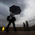 Unas turistas se protegen de la lluvia en Córdoba. EFE/Salas