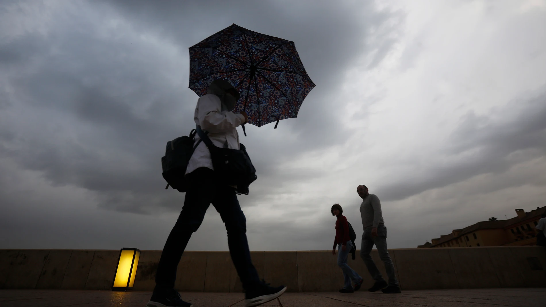 Unas turistas se protegen de la lluvia en Córdoba. EFE/Salas