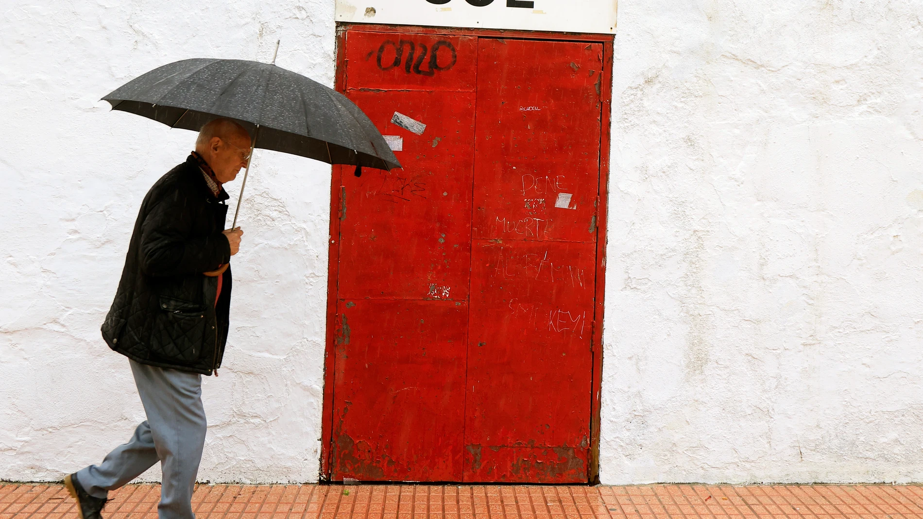 Un hombre pasa ante una de las puertas de acceso a la Plaza de Toros de Castellón, cerrada, tras la suspensión del festejo de rejones anunciado para este lunes