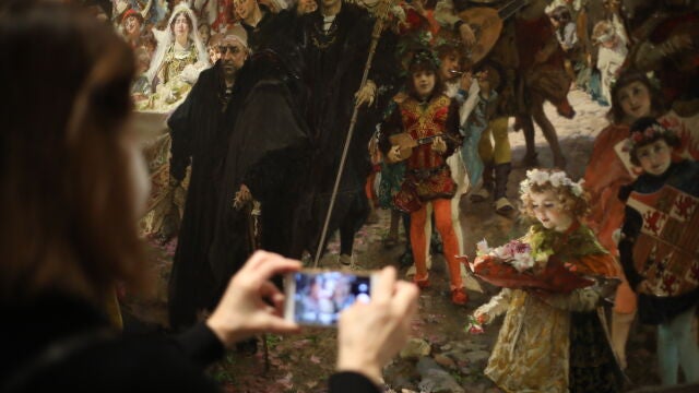 Una visitante fotografía la obra «Cortejo del bautizo del príncipe Don Juan»