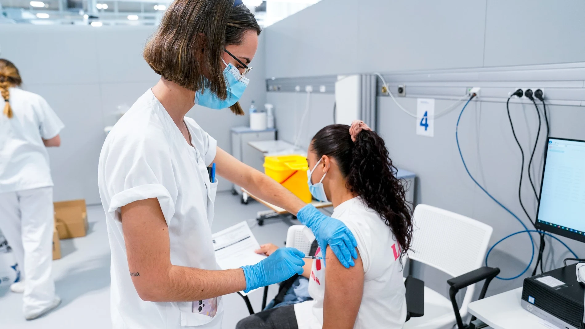 Una enfermera vacuna a una mujer en el Hospital público de emergencias Enfermera Isabel Zendal (Madrid)