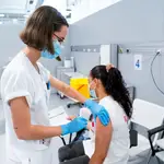 Una enfermera vacuna a una mujer en el Hospital público de emergencias Enfermera Isabel Zendal (Madrid)