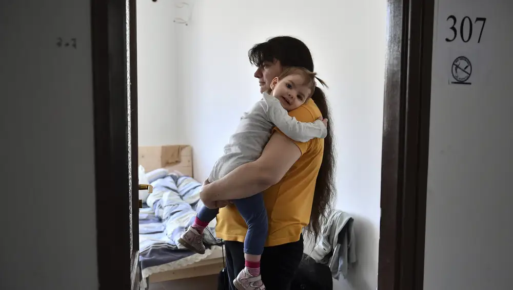 Una mujer ucraniana sostiene a su hija en su habitación en un albergue de Budapest (Hungría)