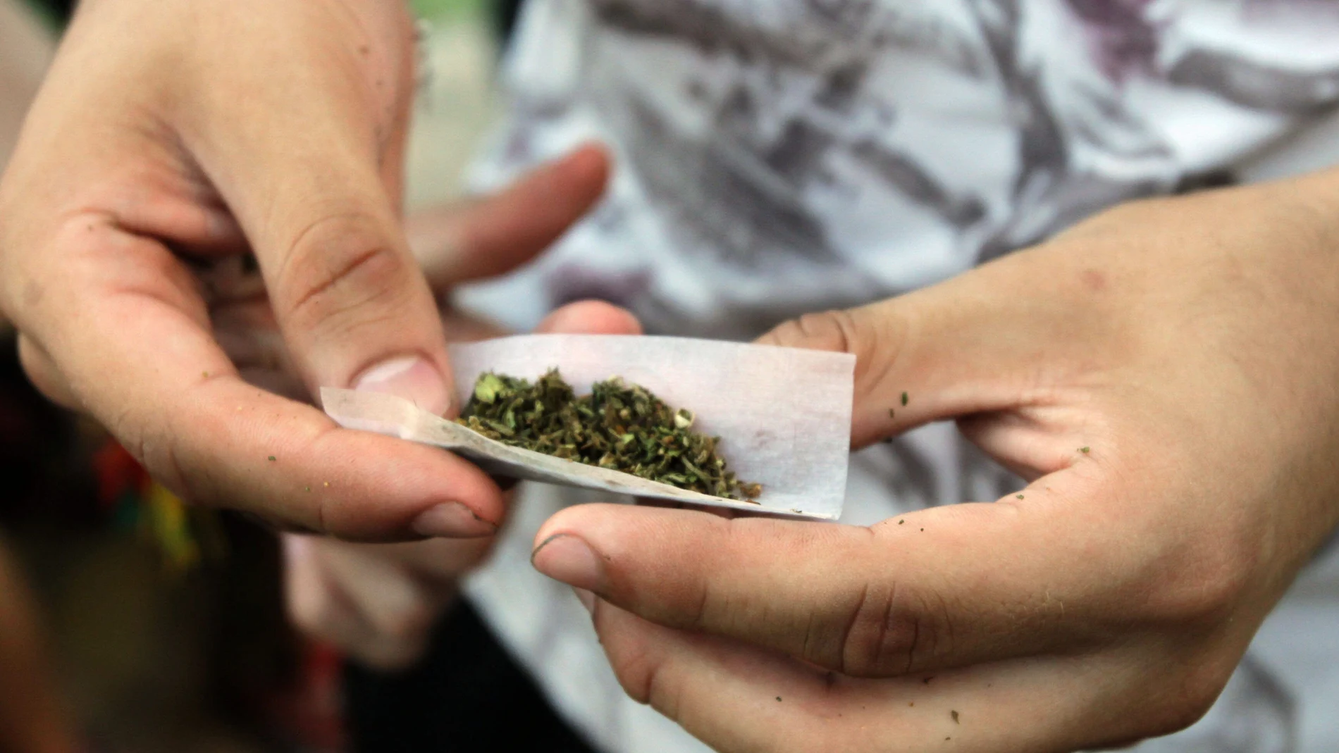 Un joven prepara un porro de marihuana, un derivado del cannabis, que sigue siendo la sustancia ilegal más consumida por los adolescentes