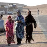 Tres mujeres del oeste del Sáhara caminan por un campo de refugiados en Tinduf, al suroeste del desierto de Argelia