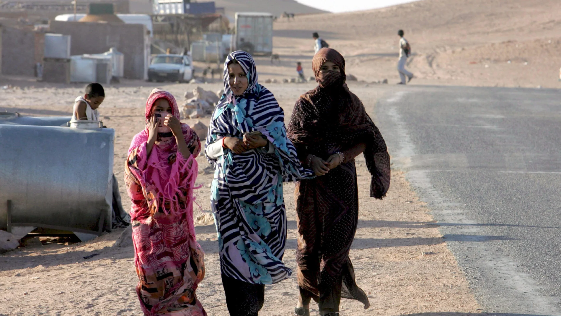 Tres mujeres del oeste del Sáhara caminan por un campo de refugiados en Tinduf, al suroeste del desierto de Argelia