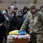 Familiares y compañeros se despiden de un soldado este domingo en el cementerio de Yuzhne. Este agente de seguridad antes del comienzo de la guerra, y veterano del conflicto del Donbas, falleció el pasado 18 de marzo en un ataque ruso. EFE/Manuel Bruque