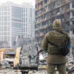 Un soldado con una ametralladora junto a un centro comercial en Kiev destruido con un misil ruso