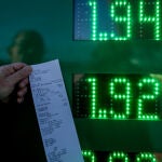 Una persona muestra el ticket del precio de su gasolina en una gasolinera