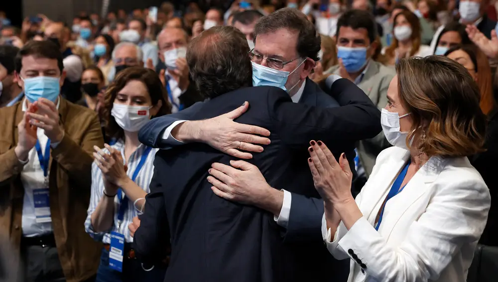 Alberto Núñez Feijóo (de espaldas) es felicitado por el ex presidente del PP Mariano Rajoy tras conocer el resultado de las votaciones.