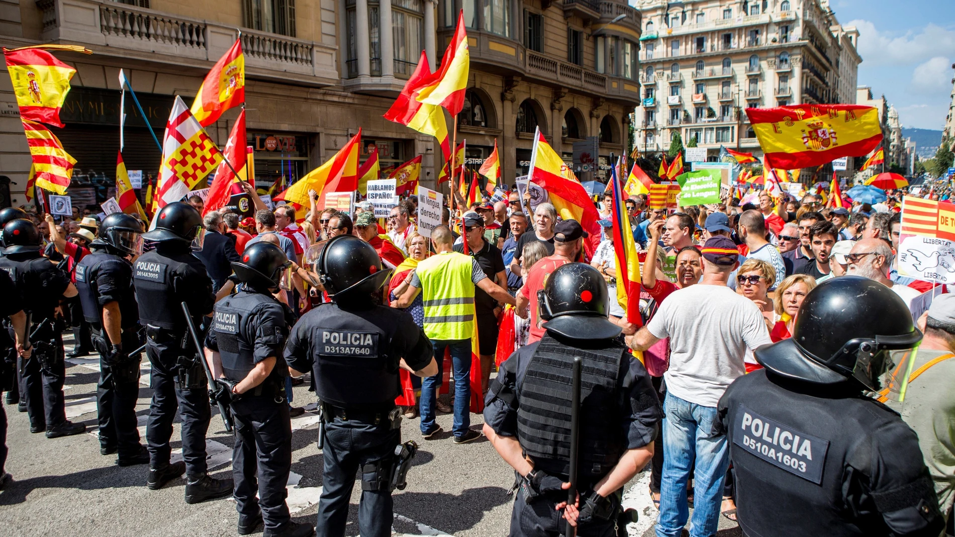 Mossos d'Esquadra impiden el paso a un grupo de personas hacia la plaza de Sant Jaume para asistir a la concentración convocada por la asociación Hablamos Español bajo el lema "Contra la imposición lingüística y el adoctrinamiento: Libertad" .