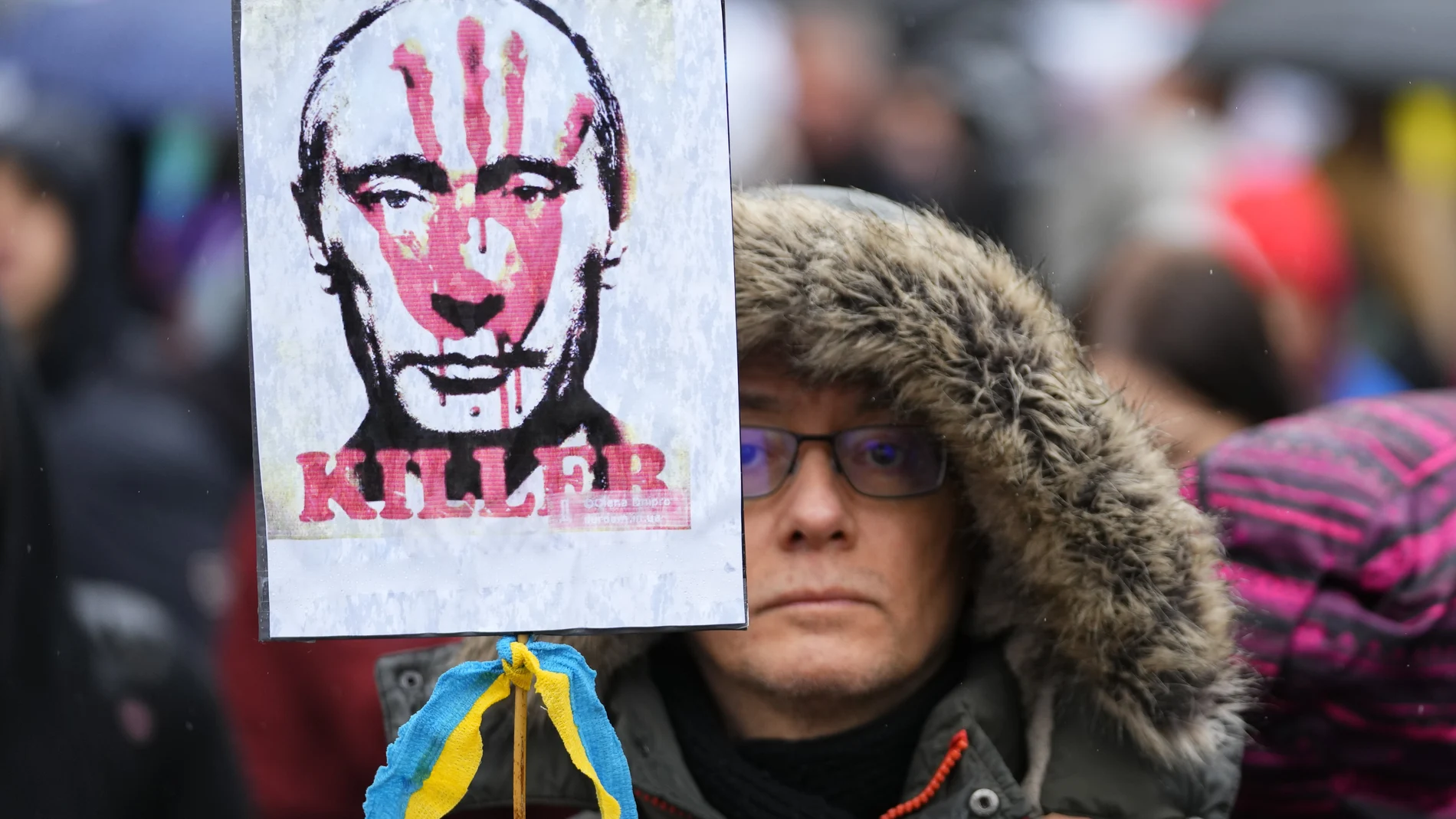 Un manifestante con una pancarta de Putin cubierta con una mano manchada de sangre durante una protesta por la guerra en Ucrania en Budapest, Hungría