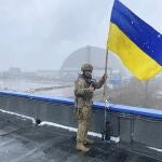 Un soldado ucraniano sostiene la bandera nacional cerca de la central nuclear de Chernóbil