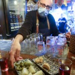 Un camarero sirve una tapa en un bar de Granada. EFE/ Miguel Ángel Molina